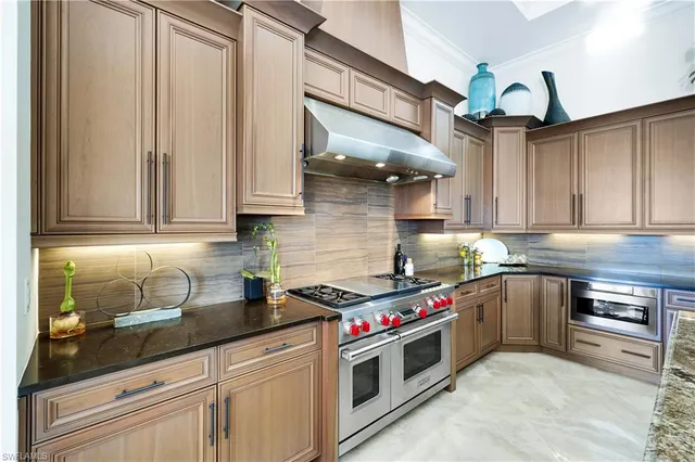 a kitchen with stainless steel appliances granite countertop a sink a stove and cabinets
