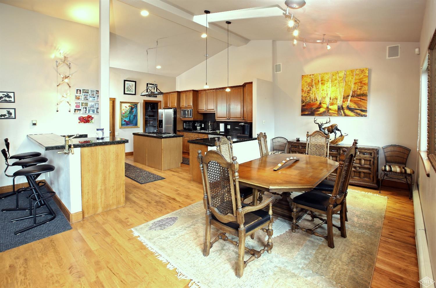 5015 Wildridge Road East, Unit A Avon, CO 81620 - Photo 3 of 22 a dining room with stainless steel appliances kitchen island granite countertop a table chairs and a refrigerator