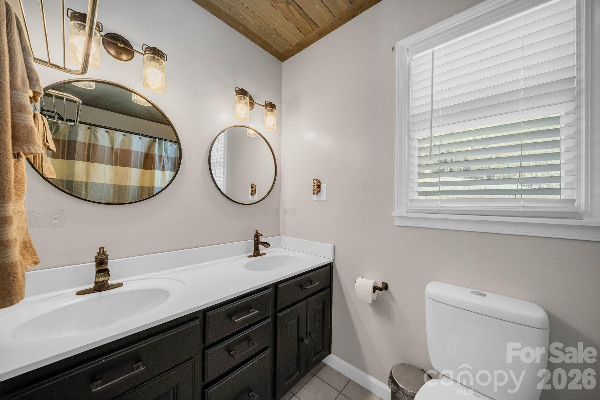 2581 Double Island Road Green Mountain, NC 28740 - Photo 25 of 48 a bathroom with a double vanity sink and a mirror