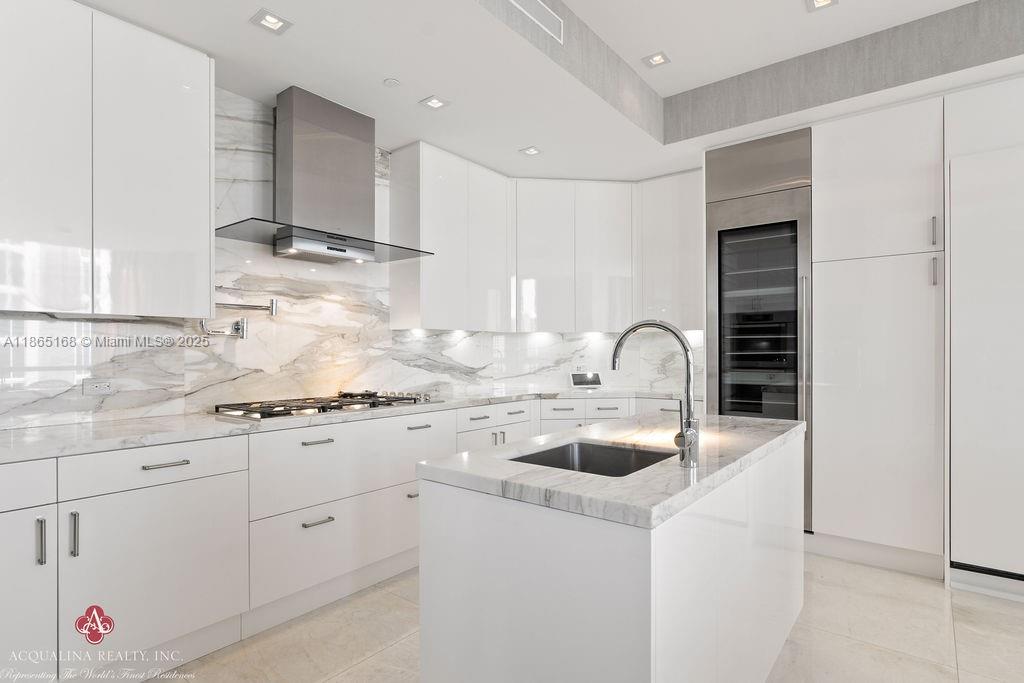 17749 Collins Avenue, Unit 902 Sunny Isles Beach, FL 33160 - Photo 27 of 82 a kitchen with white cabinets and sink