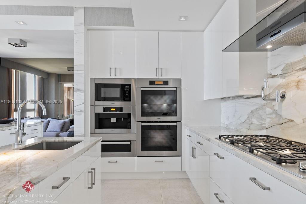 17749 Collins Avenue, Unit 902 Sunny Isles Beach, FL 33160 - Photo 32 of 82 a kitchen with granite countertop a sink and stainless steel appliances