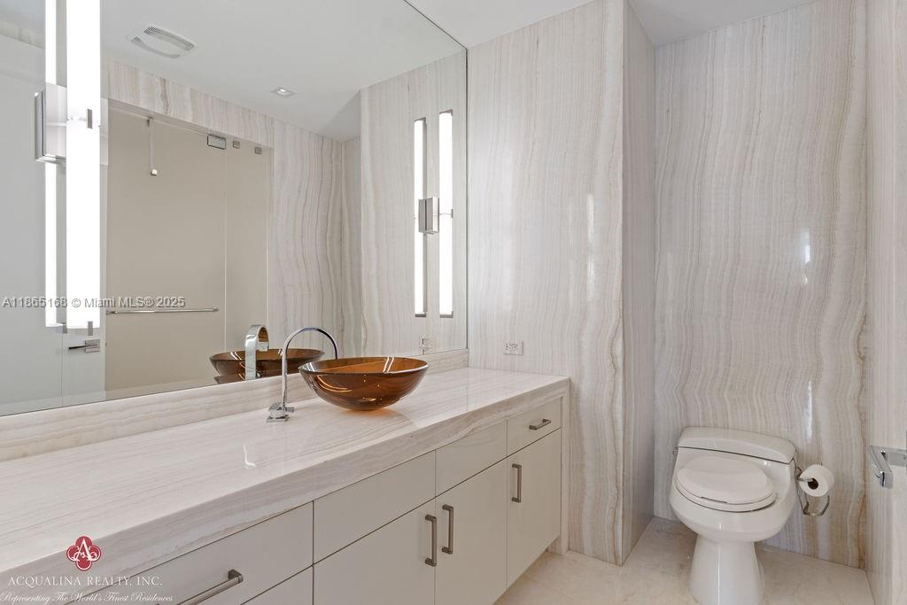 17749 Collins Avenue, Unit 902 Sunny Isles Beach, FL 33160 - Photo 45 of 82 a bathroom with a sink a toilet and a mirror