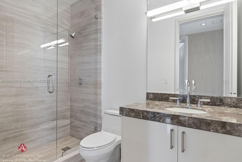 17749 Collins Avenue, Unit 902 Sunny Isles Beach, FL 33160 - Photo 57 of 82 a bathroom with a granite countertop sink a toilet and shower