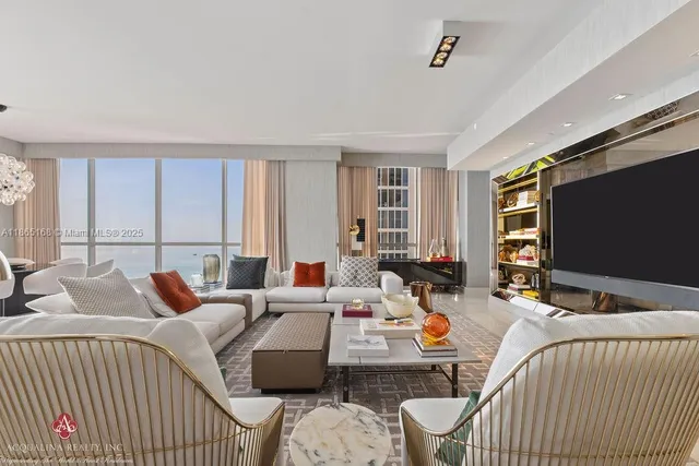 a living room with furniture and floor to ceiling windows
