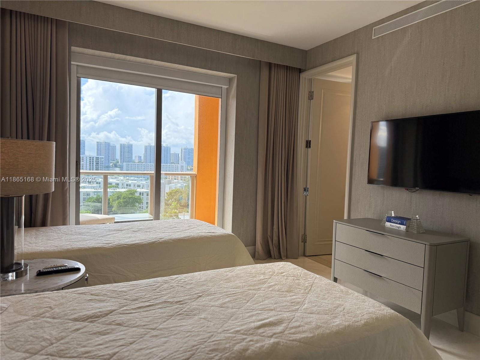 17749 Collins Avenue, Unit 902 Sunny Isles Beach, FL 33160 - Photo 76 of 82 a bedroom with a bed and a flat screen tv