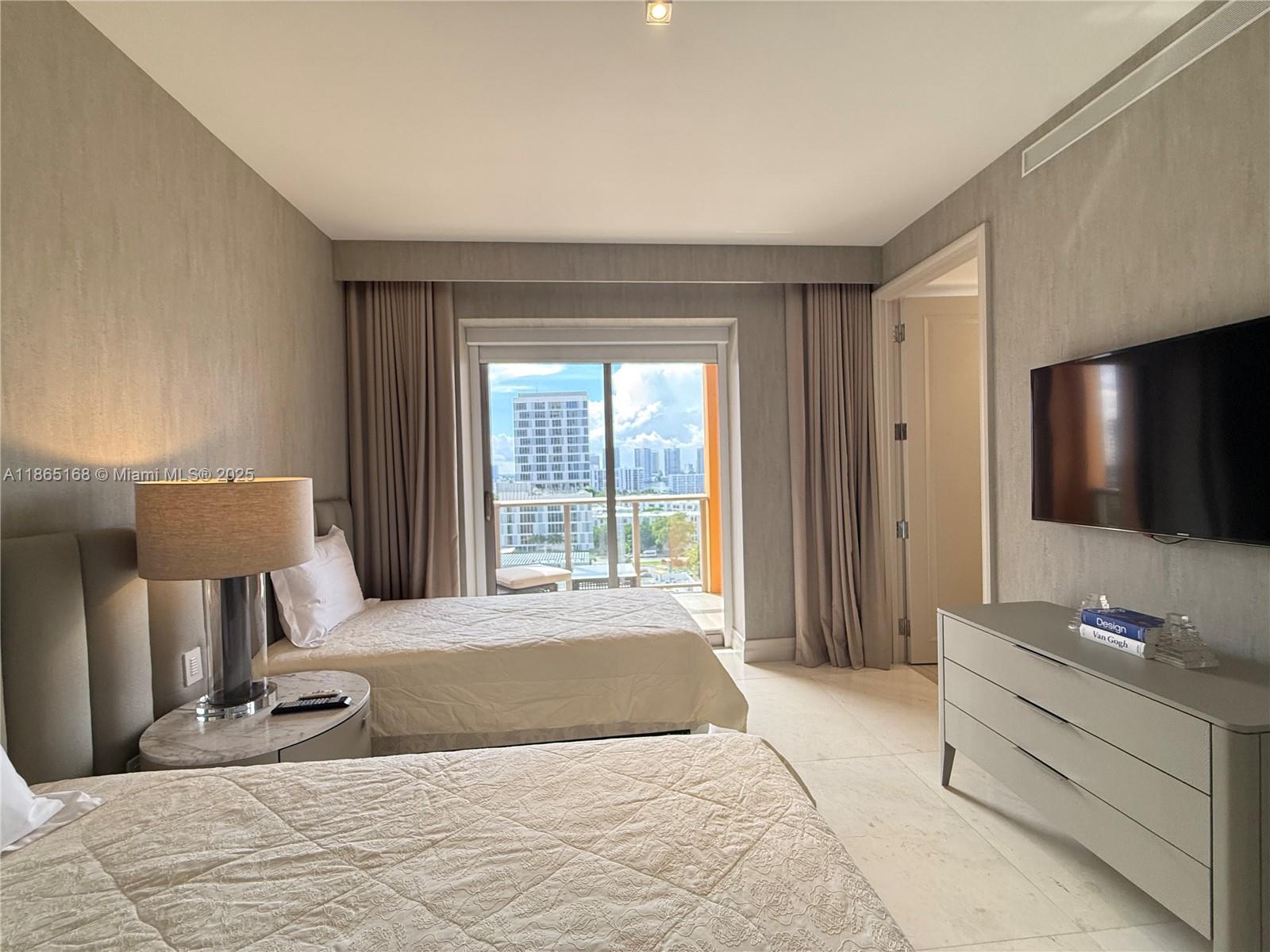 17749 Collins Avenue, Unit 902 Sunny Isles Beach, FL 33160 - Photo 77 of 82 a spacious bedroom with a bed and a flat screen tv