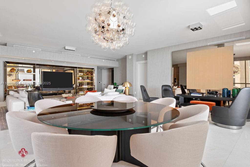 17749 Collins Avenue, Unit 902 Sunny Isles Beach, FL 33160 - Photo 10 of 82 a dining room with furniture a large window and a chandelier