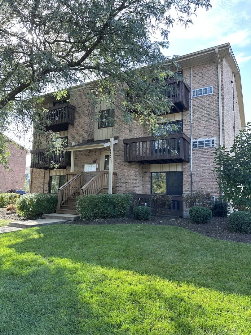 270 12th Street, Unit 2D Wheeling, IL 60090 - Photo 1 of 12 a view of a brick house with a yard