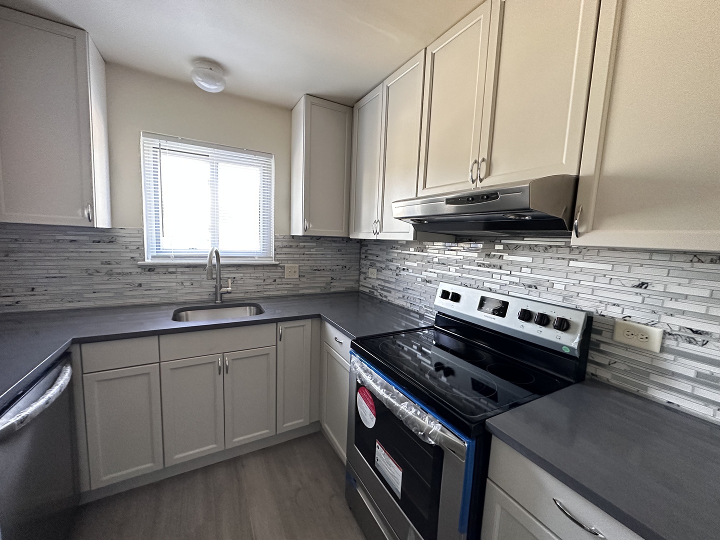 270 12th Street, Unit 2D Wheeling, IL 60090 - Photo 5 of 12 a kitchen with a stove a sink and a microwave