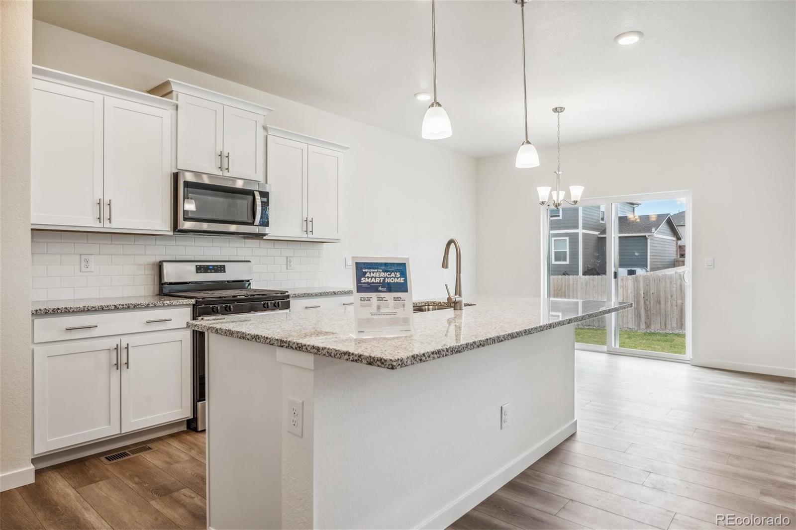 3482 Belleville Ridge Road Elizabeth, CO 80107 - Photo 4 of 21 a kitchen with stainless steel appliances granite countertop a sink a stove and a wooden floors