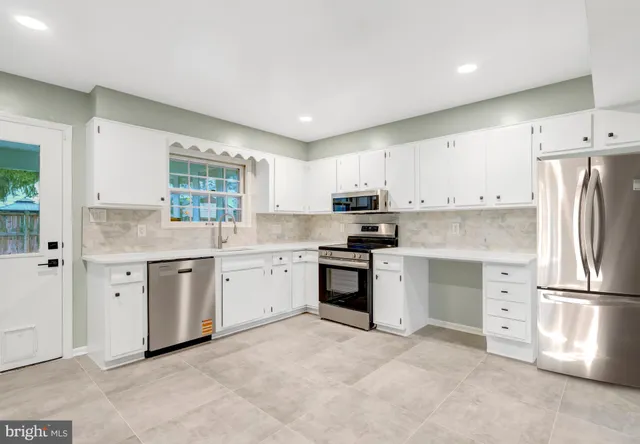 a view of a kitchen with white cabinets