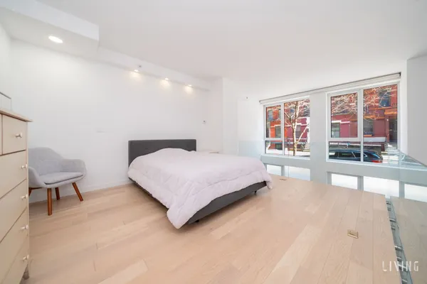 a bedroom with a large bed a large window and a couch