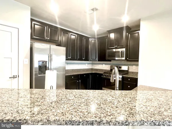 a view of a kitchen with a sink and refrigerator