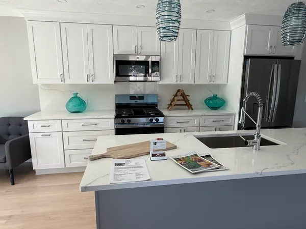 a kitchen with appliances a sink a counter and cabinets