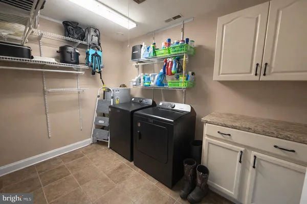 a utility room with cabinets washer and dryer
