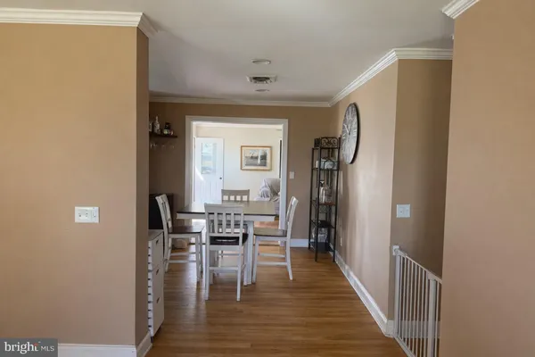 a view of hallway with dining room and wooden floor