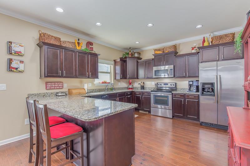 1007 Beverly Road Spring Hill, TN 37174 - Photo 10 of 24 a kitchen with granite countertop wooden floors stainless steel appliances a sink and a refrigerator