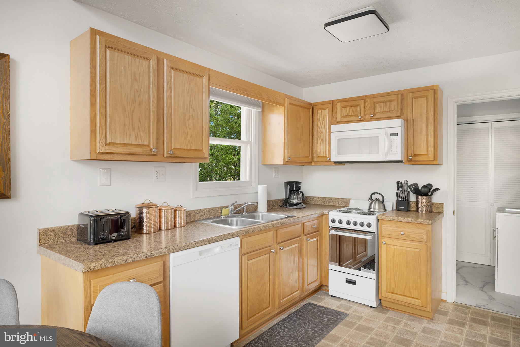 126 Flagstone Lane Berkeley Springs, WV 25411 - Photo 15 of 28 a kitchen with cabinets appliances a sink and a window