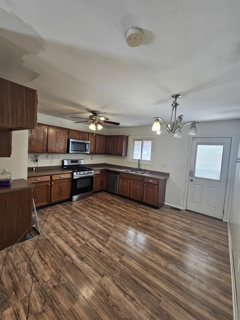 522 Manor Place Aurora, IL 60506 - Photo 5 of 16 a large kitchen with stainless steel appliances granite countertop a stove granite counter tops and white cabinets