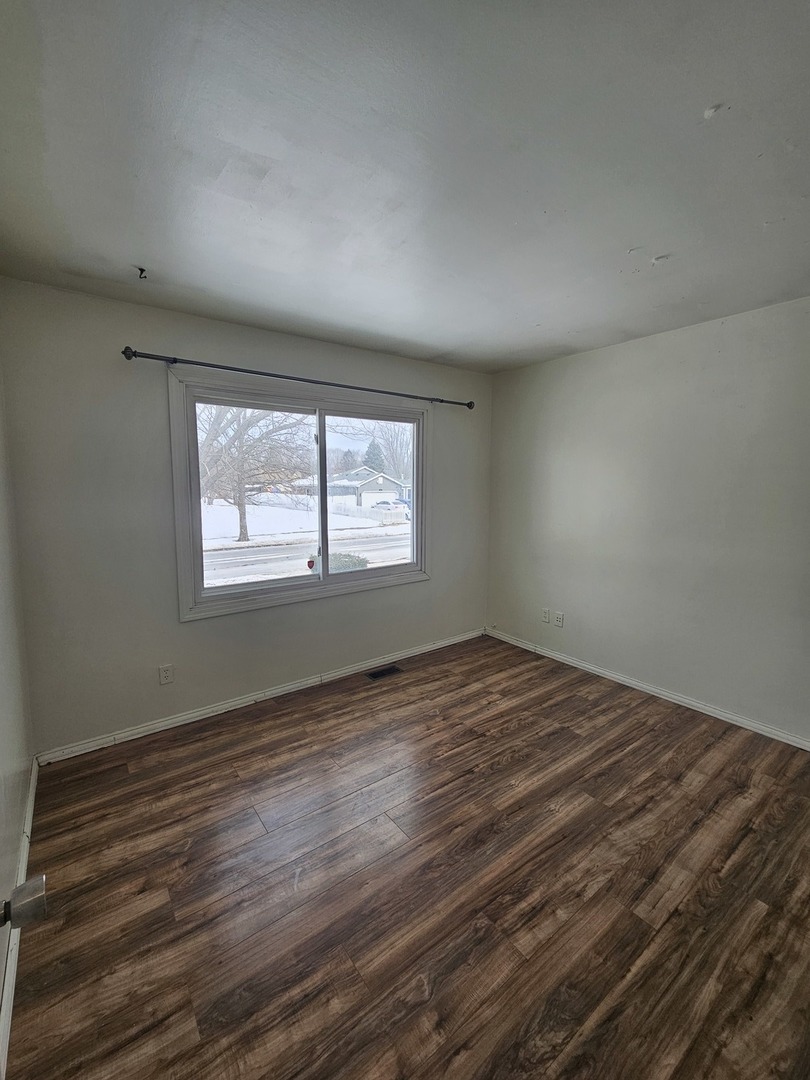 522 Manor Place Aurora, IL 60506 - Photo 6 of 16 a view of an empty room with wooden floor and a window