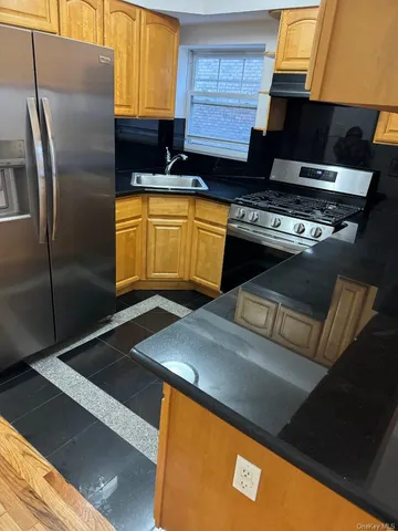 a kitchen with stainless steel appliances granite countertop a sink a stove and a refrigerator