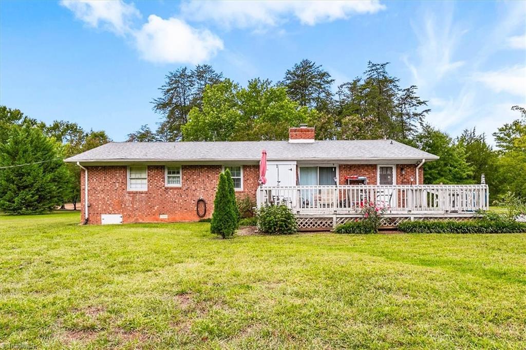 Rear of the 4-bedroom brick ranch with back deck and large yard