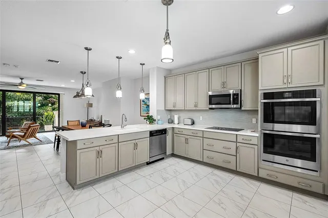 a kitchen with stainless steel appliances granite countertop a sink a stove and a refrigerator