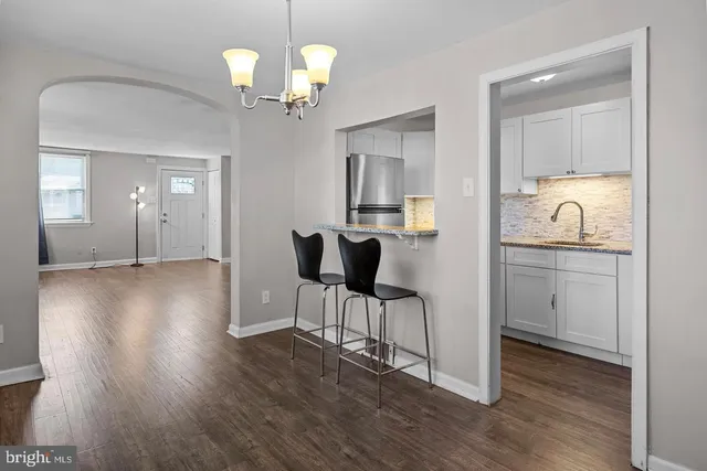 a view of a kitchen from a dining room with wooden floor