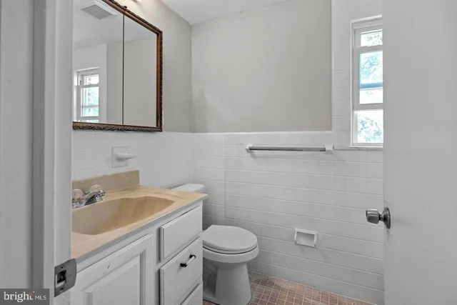 a bathroom with a sink a toilet and mirror