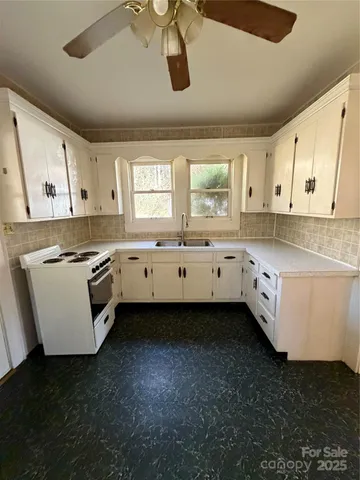 a kitchen with granite countertop white cabinets and white appliances