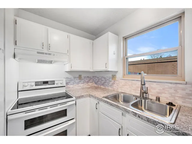 a kitchen with appliances a sink and cabinets