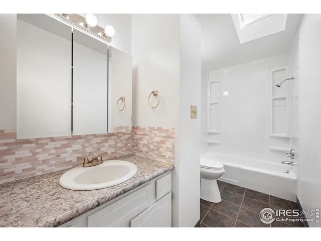 a bathroom with a sink a toilet a a mirror and shower