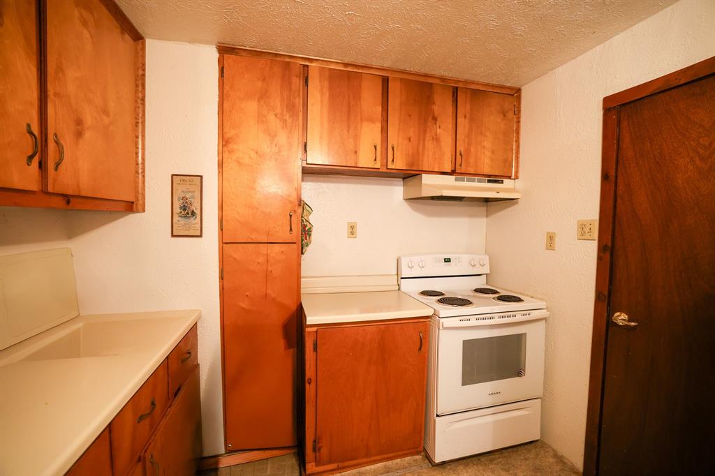 6482 County Road 4700 Commerce, TX 75428 - Photo 11 of 23 a kitchen with stainless steel appliances a stove and a refrigerator with white cabinets