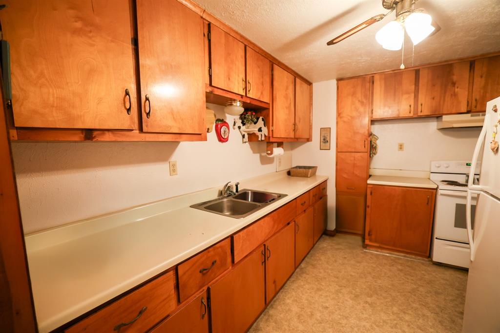 6482 County Road 4700 Commerce, TX 75428 - Photo 12 of 23 a kitchen with stainless steel appliances a sink stove and refrigerator