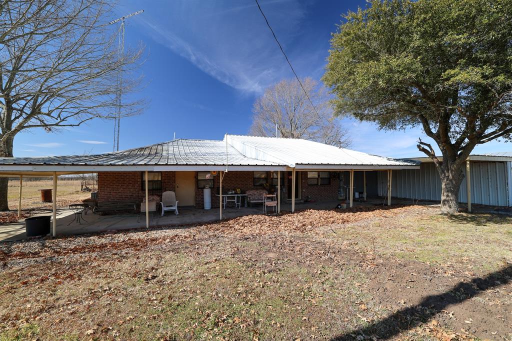 6482 County Road 4700 Commerce, TX 75428 - Photo 18 of 23 a backyard of a house with a tree