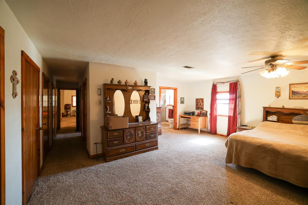 6482 County Road 4700 Commerce, TX 75428 - Photo 5 of 23 a bedroom with a bed and a chandelier