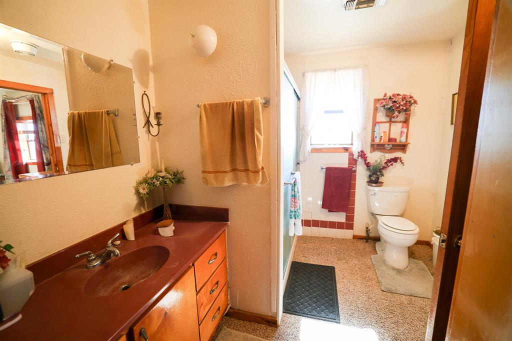 6482 County Road 4700 Commerce, TX 75428 - Photo 7 of 23 a bathroom with a sink and a mirror