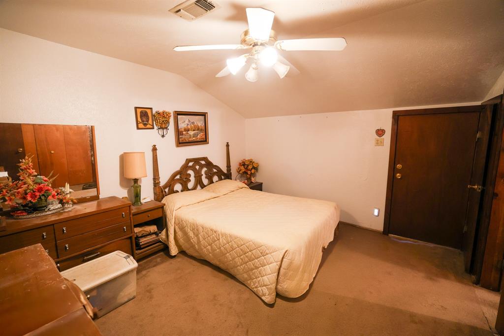 6482 County Road 4700 Commerce, TX 75428 - Photo 9 of 23 a bedroom with a bed and a chandelier