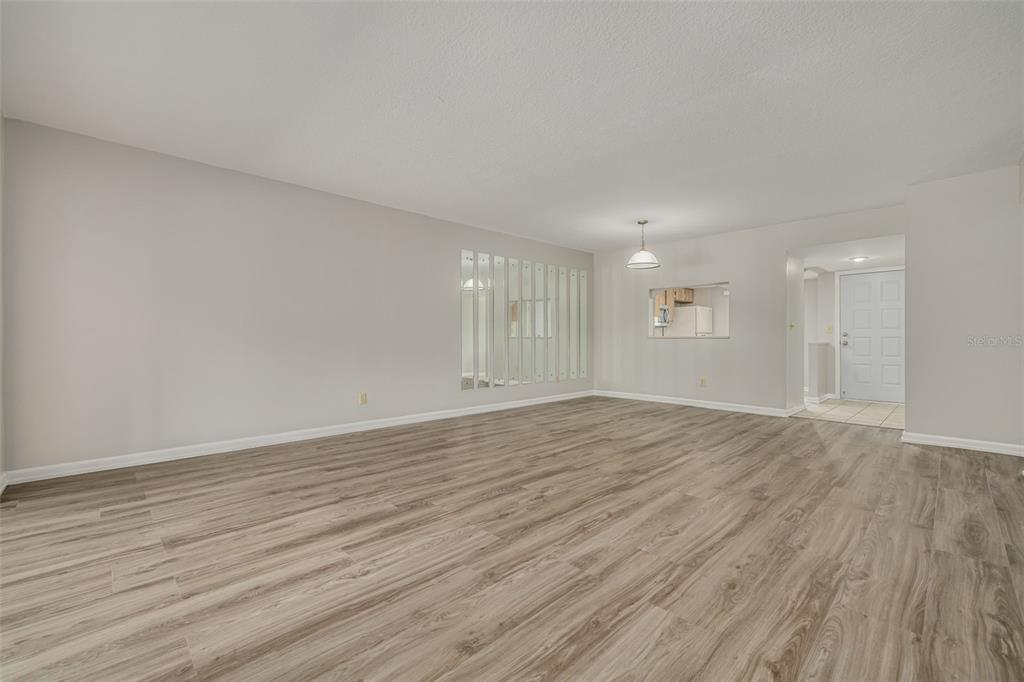 3590 Magnolia Ridge Circle, Unit C1103 Palm Harbor, FL 34684 - Photo 11 of 31 a view of an empty room with wooden floor and a window