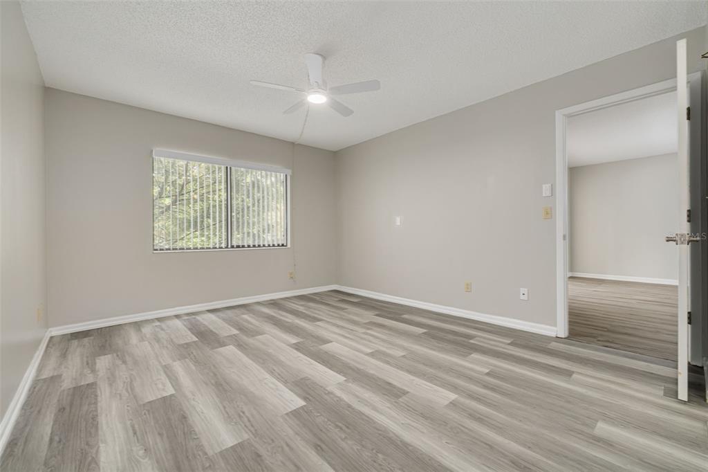 3590 Magnolia Ridge Circle, Unit C1103 Palm Harbor, FL 34684 - Photo 13 of 31 a view of an empty room with wooden floor and a window