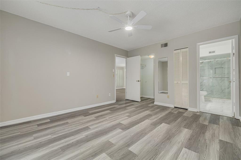 3590 Magnolia Ridge Circle, Unit C1103 Palm Harbor, FL 34684 - Photo 14 of 31 a view of an empty room with wooden floor and a ceiling fan