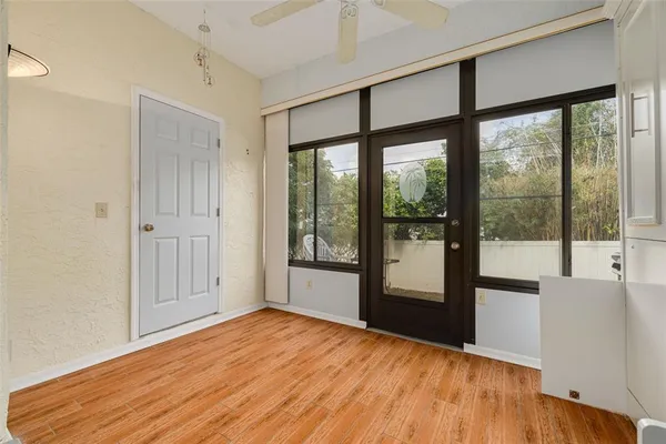 a view of empty room with wooden floor and fan
