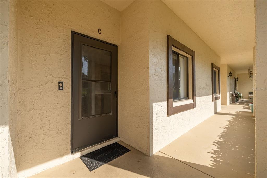 3590 Magnolia Ridge Circle, Unit C1103 Palm Harbor, FL 34684 - Photo 3 of 31 a view of a hallway with wooden floor and a living room