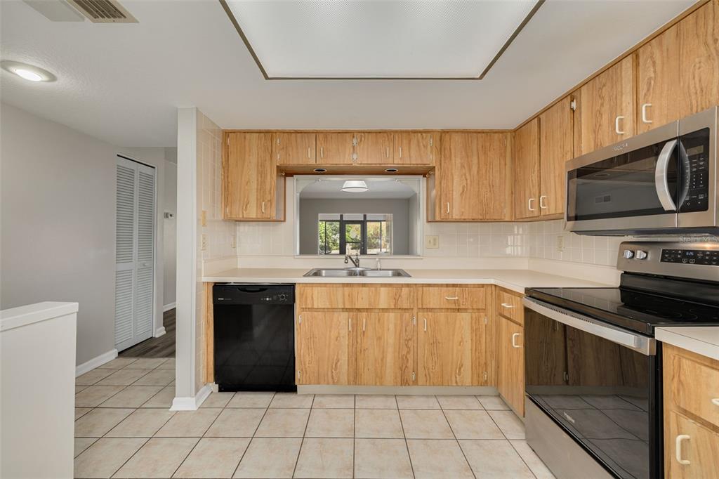 3590 Magnolia Ridge Circle, Unit C1103 Palm Harbor, FL 34684 - Photo 6 of 31 a kitchen with a sink stove and cabinets