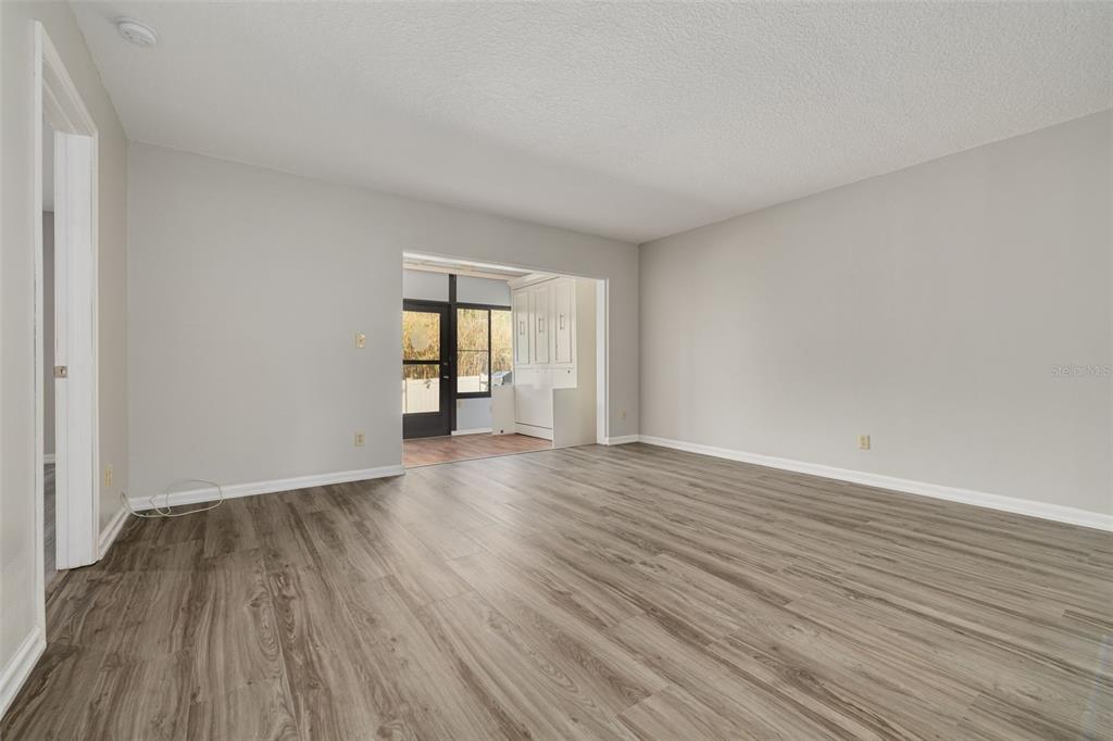 3590 Magnolia Ridge Circle, Unit C1103 Palm Harbor, FL 34684 - Photo 8 of 31 a view of an empty room with wooden floor and window