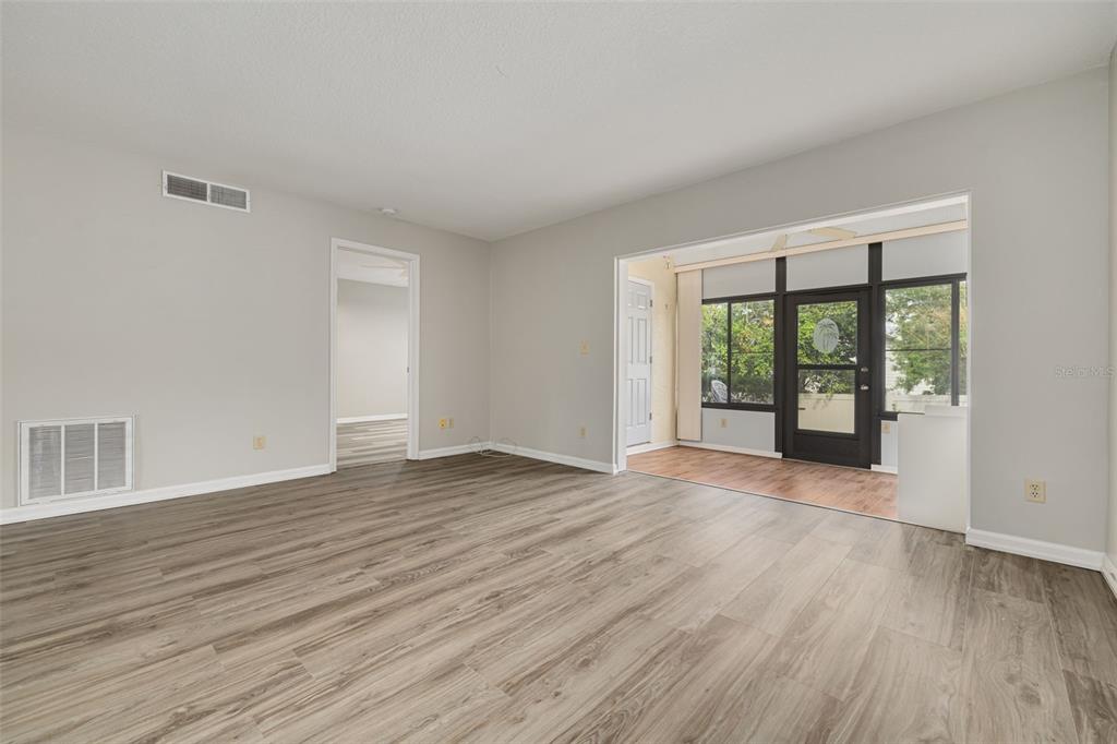 3590 Magnolia Ridge Circle, Unit C1103 Palm Harbor, FL 34684 - Photo 9 of 31 a view of an empty room with wooden floor and a window