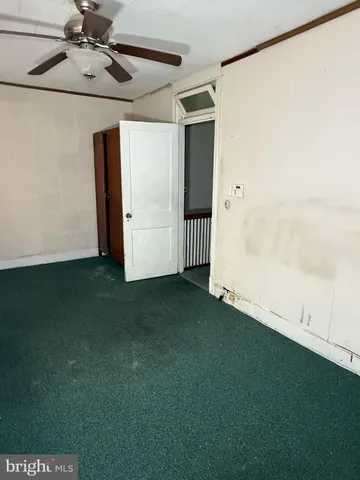 a view of empty room with ceiling fan and window