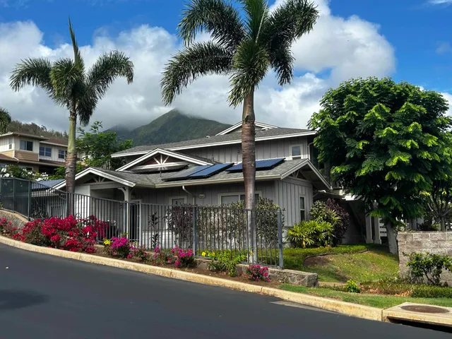 a view of a street with a building and palm tree