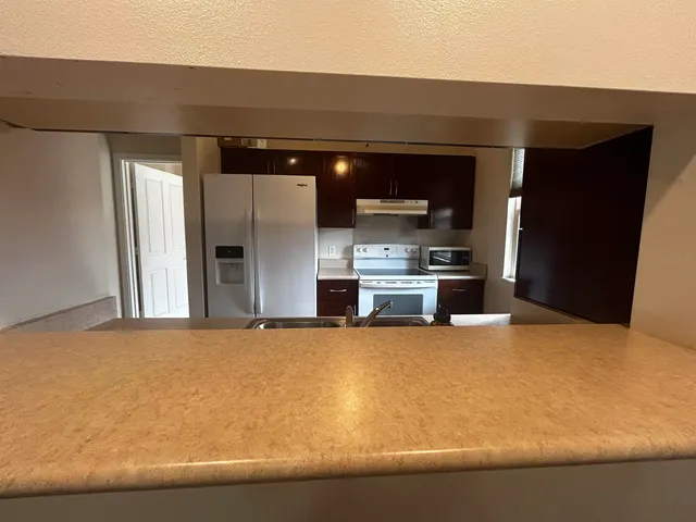 a kitchen with stainless steel appliances kitchen island sink refrigerator and stove