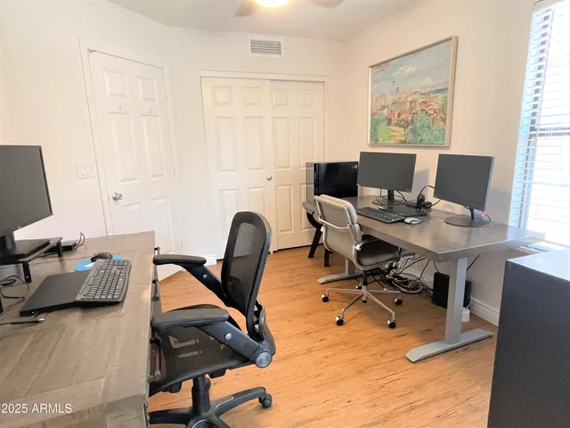 a view of a workspace with furniture and a window